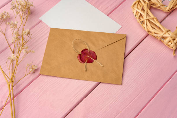 istock Envelope with letter on pink wooden background top view 1421043713