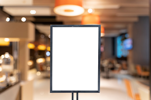 Mock up poster frame template in cafe table and seats interior advertising banner. Vertical empty advertising poster mock-up at the entrance of restaurant