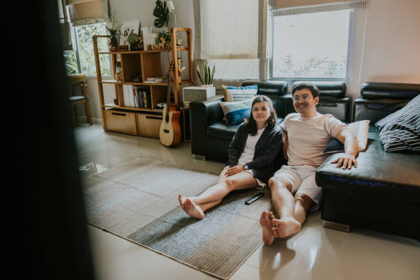 istock Thai couple watching tv at home 1421043931