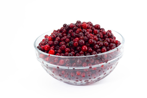 Fresh red Lingonberries in a glass bowl isolated on white background