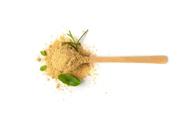 Soup powder in wooden spoon isolated. Instant powdered broth, bouillon concentrate with herbs and spices on white background top view