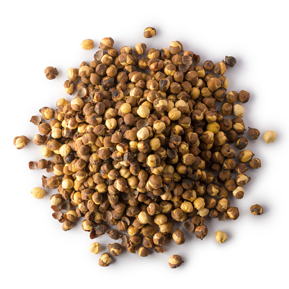 pile of roasted and salted black chickpeas, also known as bengal gram or desi chickpea, traditional and native oil free snack of india isolated on white background, taken from above