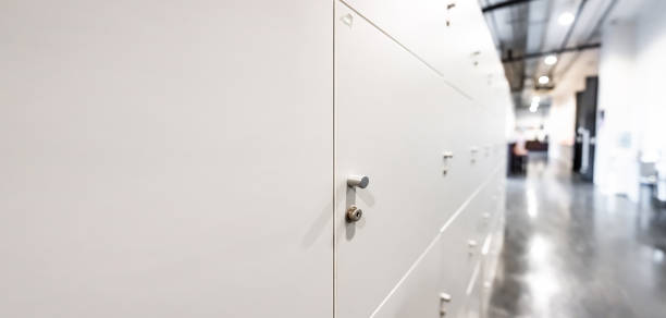 istock Large gray locker with each locker closed located beside corridors inside building are dimly lit. 1421049498