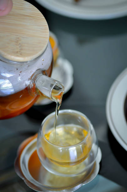 istock pouring tea , tea cup and tea pot 1421050725