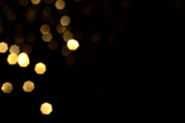 istock Golden blurred bokeh lights on black background 1421052412
