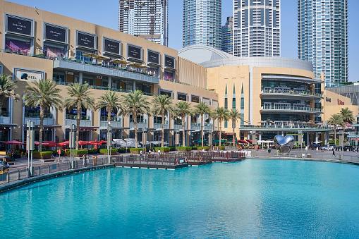 Dubai, United Arab Emirates - May 30, 2022: view of The Dubai Mall and the Burj Khalifa Lake on a sunny day. Few people visiting the place.