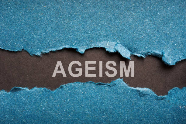 Black piece of paper with word Ageism. stock photo