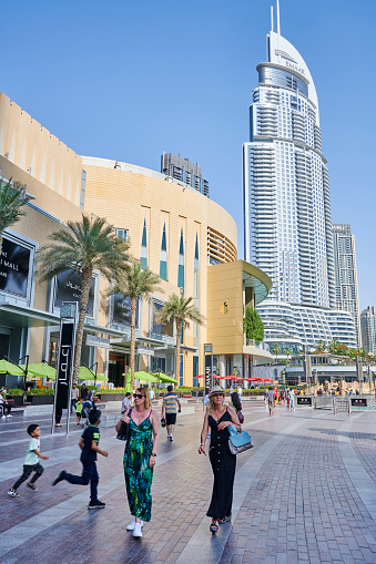 Dubai, United Arab Emirates - June 03, 2022: tourists walking and relaxing at the large terrace outside The Dubai Mall.