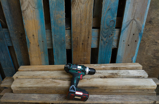 A Cordless drill lying down after being used on pallets