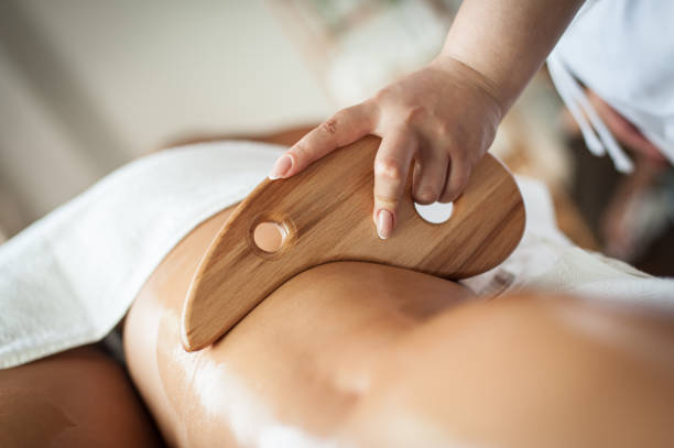мадеротерапевтический антицеллюлитный массаж женской ноги деревянным шпателем - massage therapist massaging sport beautician стоковые фото и изображения