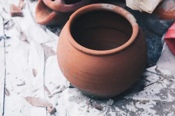 Closeup of newly made large unglazed clay pot jar - can be used as water container, fish aquarium, cooking or planting flowers, herbs and vegetables. Selective focus. Copy space.