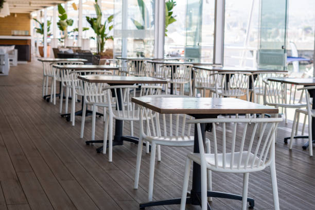 istock Empty restaurant with white chairs and wooden tables 1421061927
