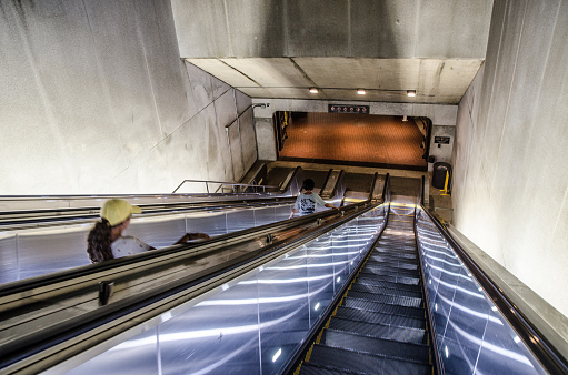 Teenage girl going down escalator to subway