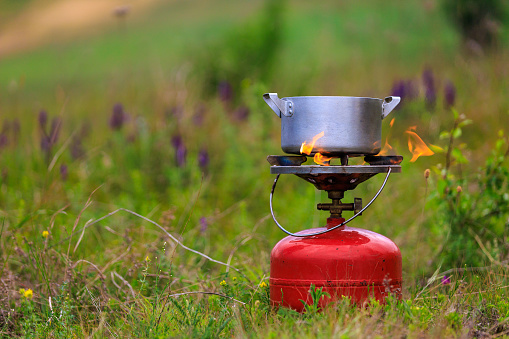 Pot on a gas burner in field conditions. Background with copy space for text