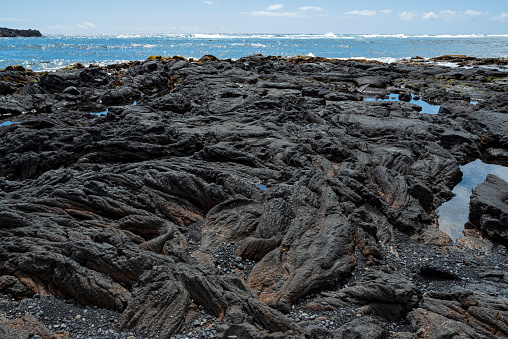 rocky punalu'u black sand beach and ocean on horizon along kau coast of southeastern hawaii