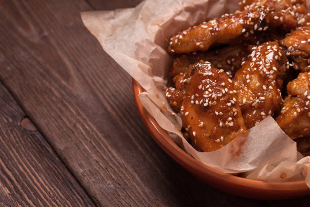 istock Chicken wings on a wooden table. 1421067539
