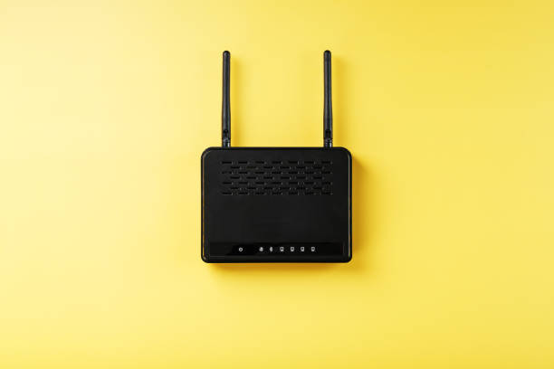 istock Black Wi-Fi router on a yellow background with free space. 1421067640