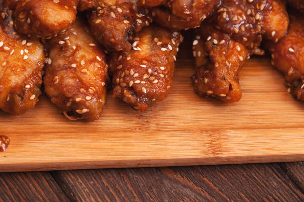 istock Chicken wings on a wooden table. 1421068216
