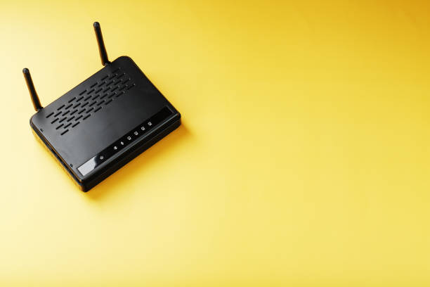 istock Wi-Fi router in black on a yellow background with free space. 1421068906
