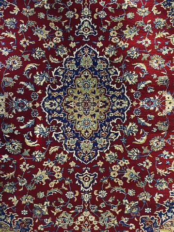 Persian Carpet. Closeup of national popular antique oriental backdrop, beautiful artistic, texture. Abstract repeating design of red blue flower on yellow color style background wallpaper texture.