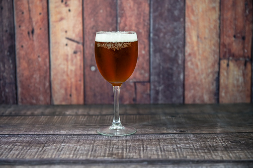 Ice cold beer glass on wooden background. Copy space