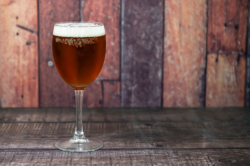 Ice cold beer glass on wooden background. Copy space