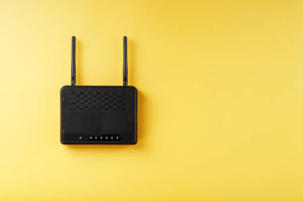 istock Wi-Fi router in black on a yellow background with free space. 1421069889