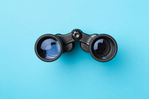 istock Black binoculars on color background. Top view 1421070325