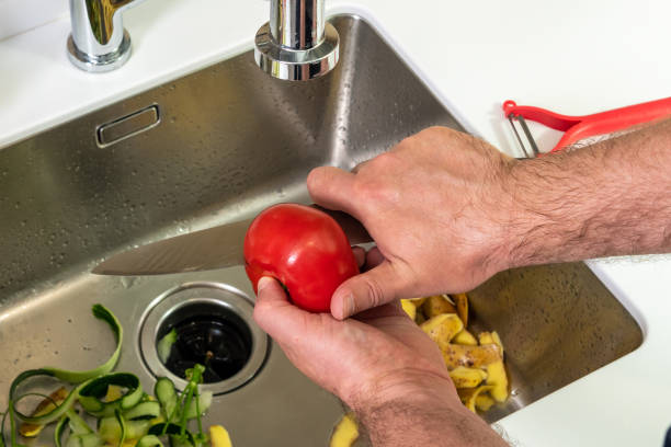 istock Knife cuts tomato, cleaning and cutting fresh vegetables in the kitchen 1421071733