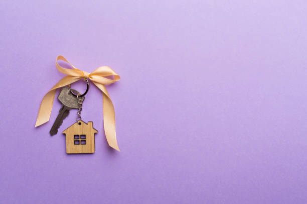 House key with golden bow on color background House key with golden bow on color background. florida real estate house home interior stock pictures, royalty-free photos & images