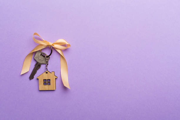 house key with golden bow on color background - celebration imagens e fotografias de stock