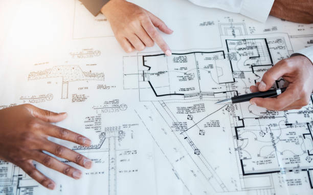 istock Hands of architects, engineers and building construction workers planning project with blueprint in meeting at work, working on house and talking with document. Creative designer with paper at table 1421072617