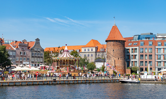 Gdansk, Poland - August 13, 2022: A picture of the Swan Tower and a Merry Go Round in St. Dominic's Fair.