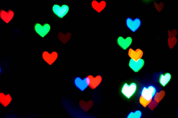 istock Multi colored blurred lights in the shape of hearts in the dark. 1421077695
