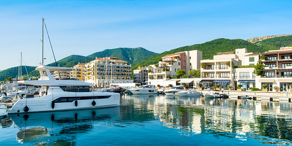 Tivat, Montenegro - June 28, 2021: Panoramic sunset view of the yacht marina in Porto Montenegro with waterfront residences and  the beautiful promenade