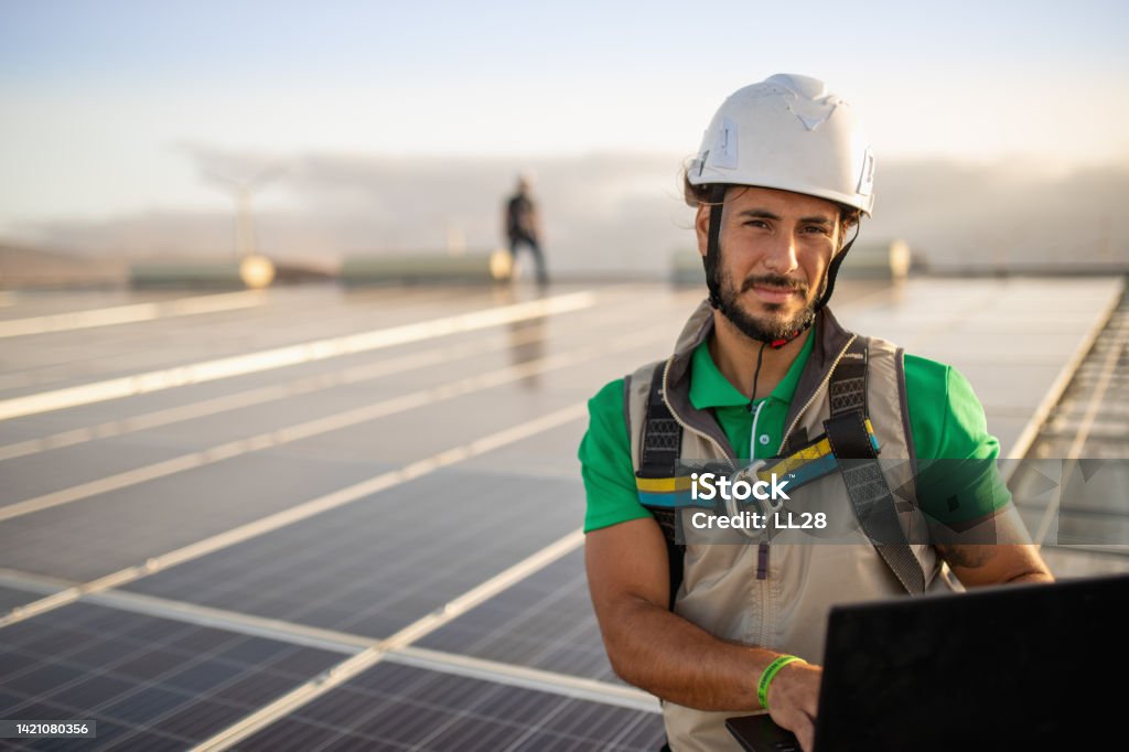 Checking productivity at solar power plant with laptop Checking photovoltaic productivity at solar power plant with laptop, engineer working outdoors at solar power plant stock photo Solar Panel Stock Photo