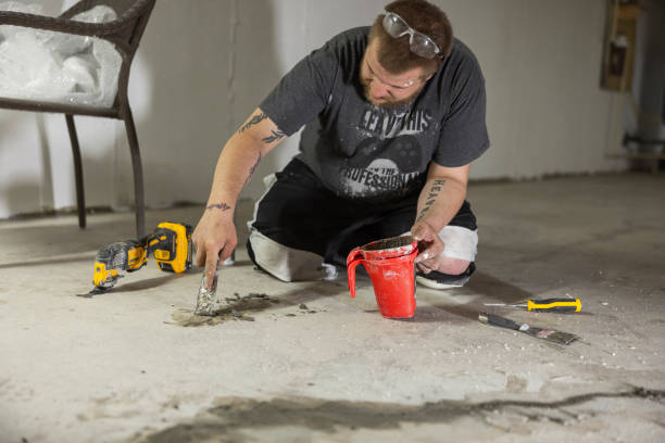 istock Sealing cracks in basement floor. Construction worker sealing cracks with hydraulic cement for waterproofing. 1421081684