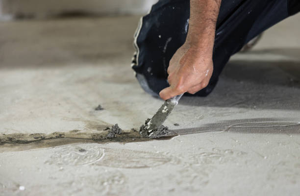 Basement waterproofing. Worker using hydraulic cement for sealing cracks in the basement floor. stock photo