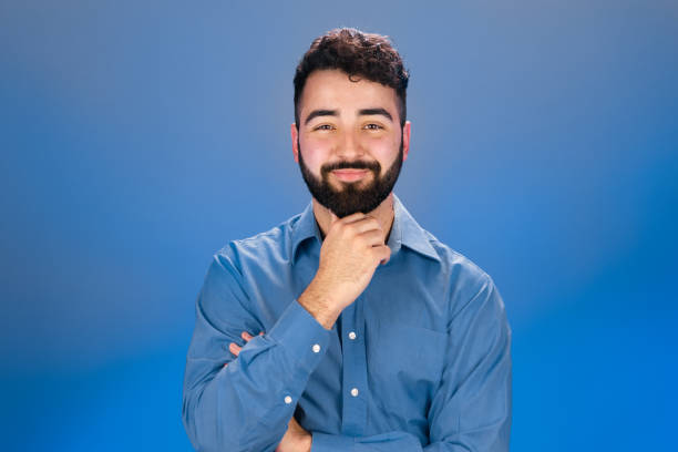 istock Young man touching his chin and looking att camera 1421081968