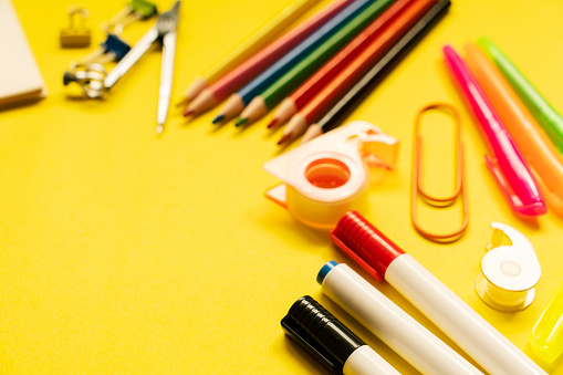 School and office supplies on yellow background