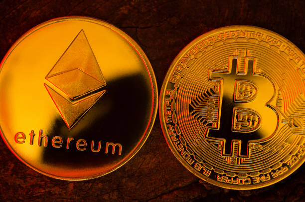 monedas de oro de ethereum y bitcoin en una superficie de madera, primer plano - ucrania, izmail, 17.03.2022 - éter fotografías e imágenes de stock