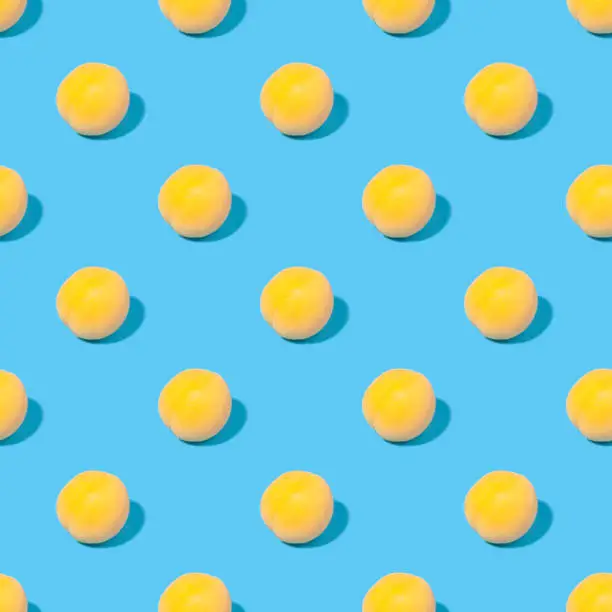 Seamless summer background with apricots - absolutely seamless pattern of yellow apricots on a blue background
