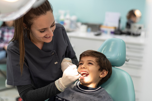 dentist examines a child's mouth in his office