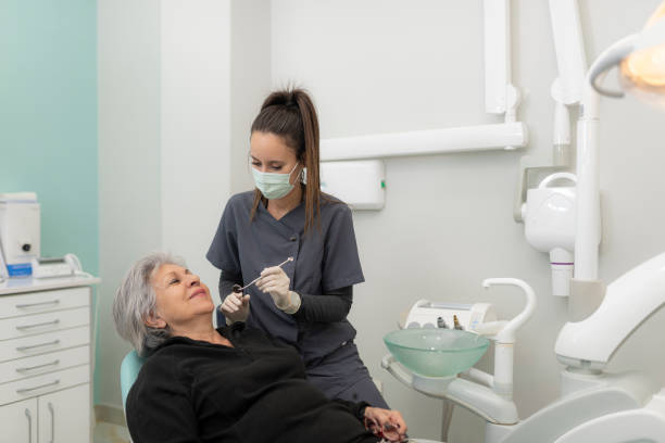 Dentist sets out to examine the mouth of a 70-year-old woman stock photo