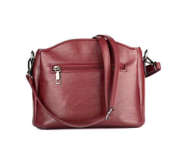 istock Women's burgundy leather handbag with a long strap on a white background. 1421088915