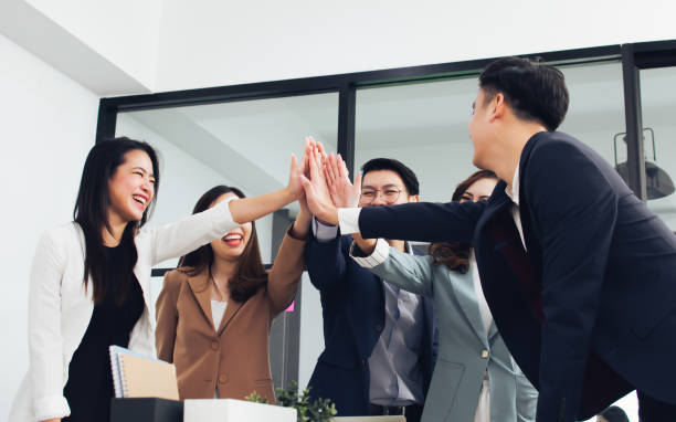 istock Group of Asian teamwork businesspeople making high five with togetherness or tag their hands with happiness and confidence after getting success on their projects and goal achievement. 1421089152