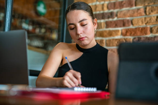 istock Woman taking notes at a business meeting 1421090514