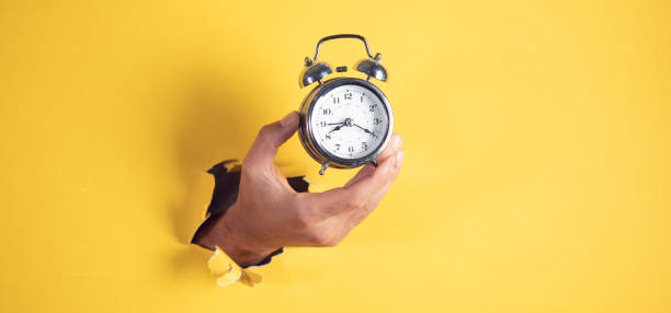 istock male hand holding vintage clock 1421090596