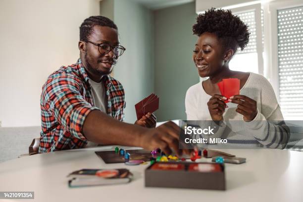 Young People Enjoying At Home And Playing Board Game Stock Photo - Download Image Now