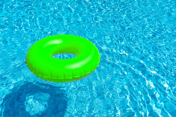 istock Green ring floating in blue swimming pool. Inflatable ring, rest concept 1421092717